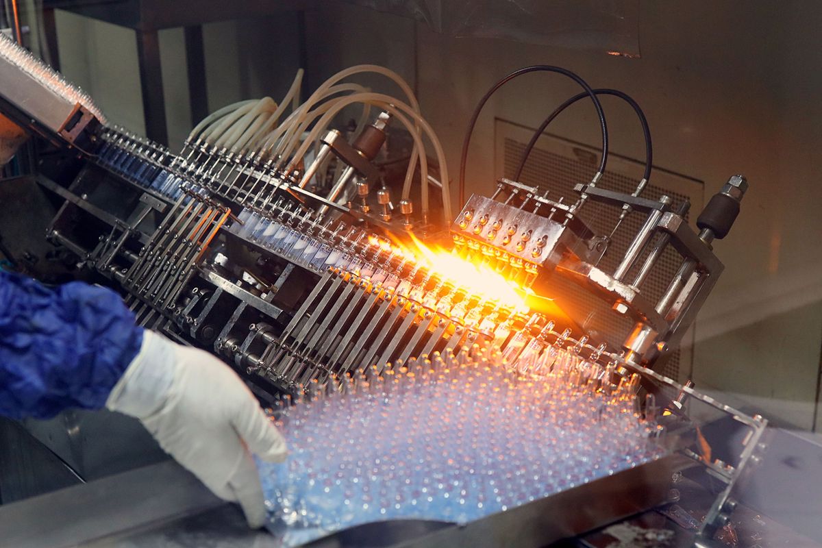 Glass ampoules moving through an automated pharmaceutical production line.