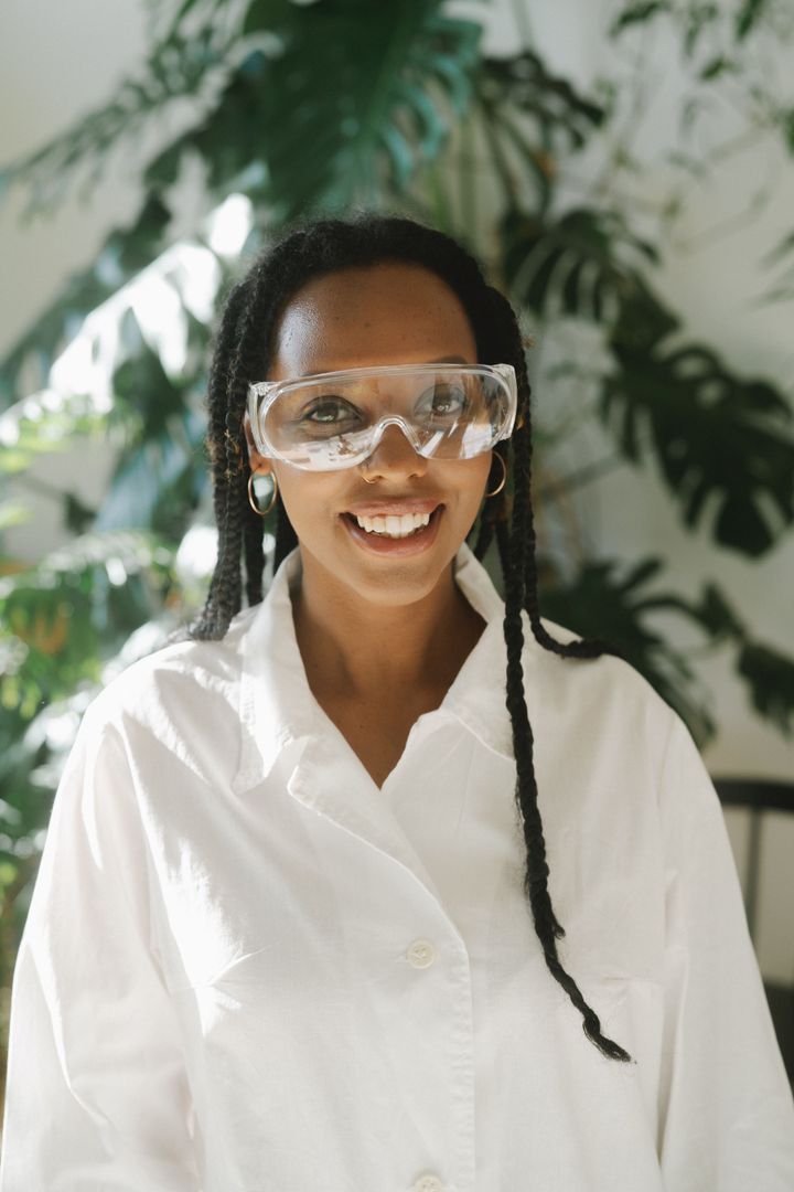 A laboratory professional wearing a white coat and protective eyewear.